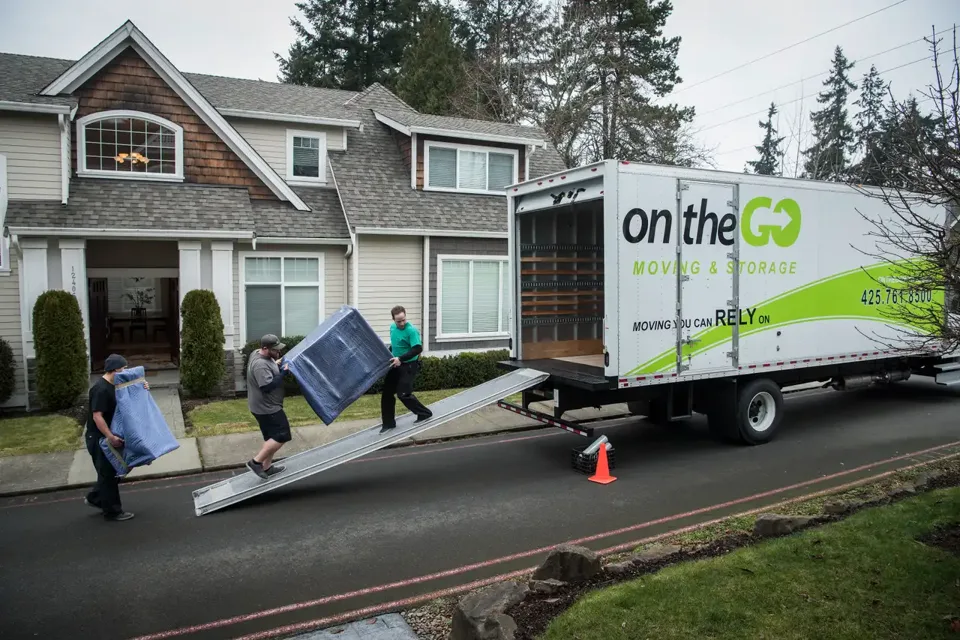 Three On The Go Moving movers loading furniture onto a moving truck